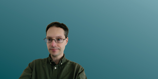 Mark Smith in front of a blue background.