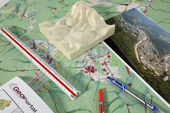 Bauplan mit 3D Höhemodell, Landschaftsbildern und Stiften.