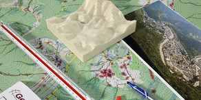 Bauplan mit 3D Höhemodell, Landschaftsbildern und Stiften.