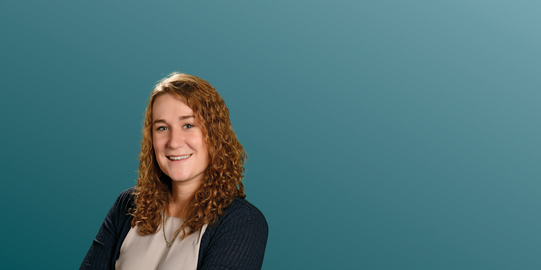 Katharina Künzel in front of a blue background.