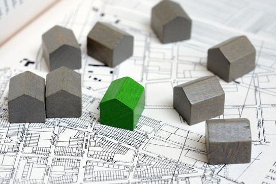 Small models of houses are on a building plan.