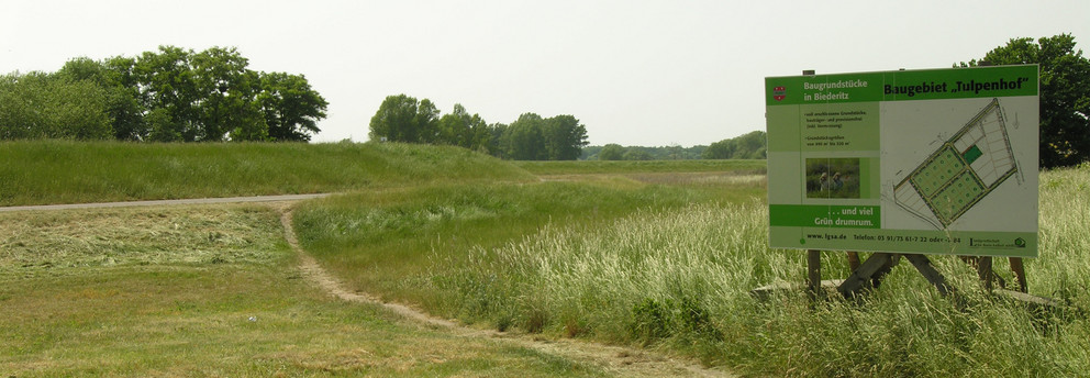 Forest path with information sign depicting a plan for new building lots.